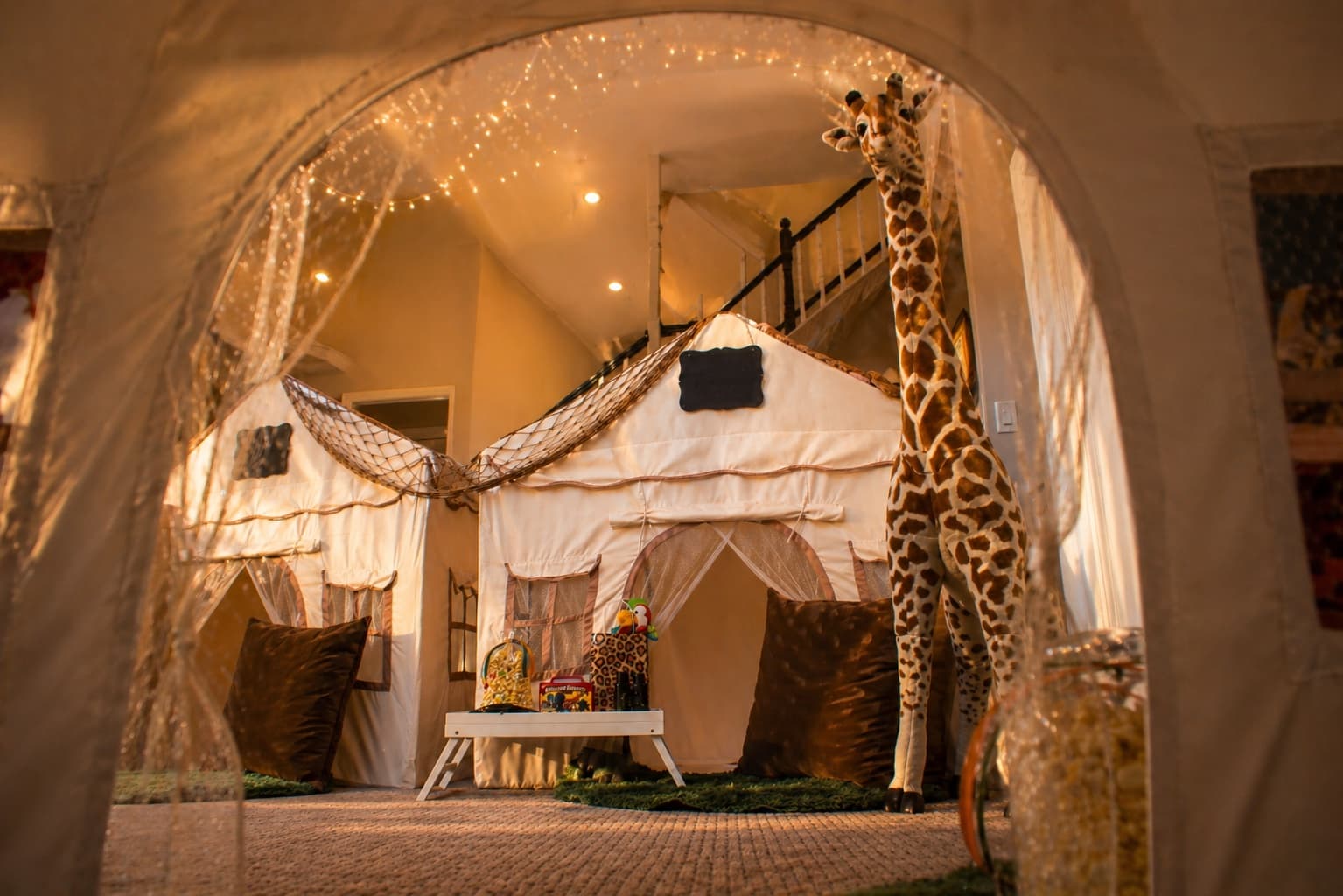 Step into the jungle! A safari camp setup that brings the wild indoors with towering giraffes and explorer vibes.